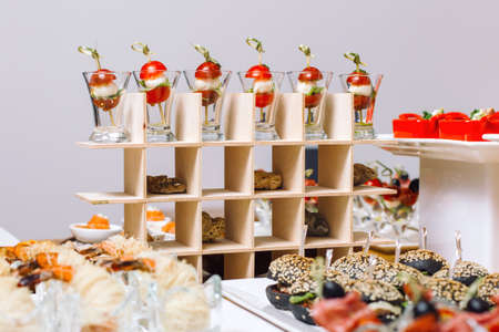 Canapes on toothpicks, appetizer, pinchos, spanish food. Quail eggs and cherry tomatoes.の写真素材