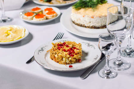 Wedding table with treats, beautiful setting. In the foreground, a meat salad with pomegranate seeds.の写真素材