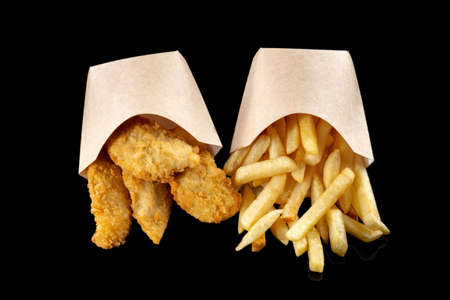 Image of French fries and deep-fried fish pieces. Fish and chips, in nice paper bags.の写真素材