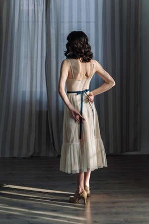 Cute young girl stands in the studio on the background of curtains. Full-length photo.の写真素材