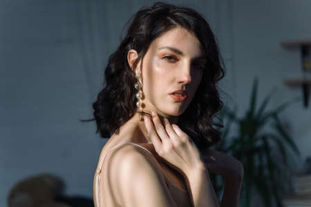 Close up studio portrait of a pretty brunettes looking straight at the camera with her mouth open. Sun glare on the face.の写真素材