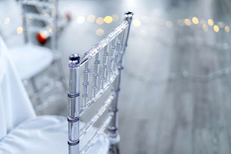 Transparent plastic chairs for wedding guests. Macro shot of the back of a chair.