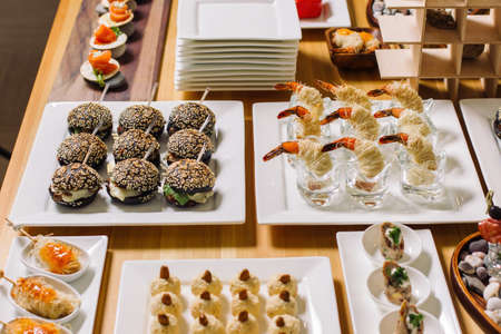 Mini burgers with meat on the table prepared for the guests of the event. Catering and guest meals during the event. Large cheese plate2.の写真素材