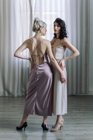 Studio portrait of blonde woman and brunettes, young and beautiful. Vertical photo, hip portrait.の写真素材