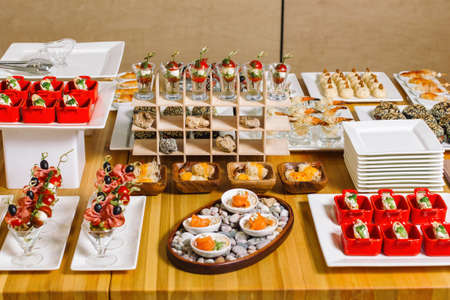 Mini burgers with meat on the table prepared for the guests of the event. Catering and guest meals during the event. Large cheese plate.の写真素材
