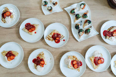 Pancakes with strawberry jam, catering table. Other dishes in the background.の写真素材