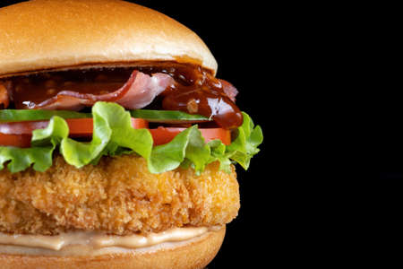 Bacon cheeseburger hamburger isolated on black. BBQ sauce and lettuce.の写真素材