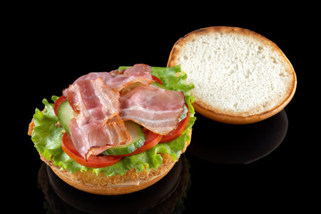 Bacon cheeseburger hamburger isolated on black. BBQ sauce and lettuce.の写真素材