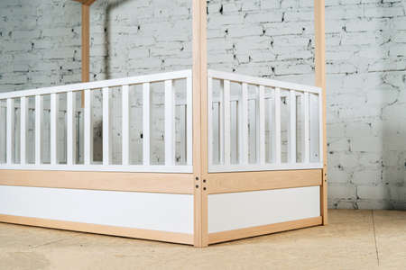The image of the childs bed, in the frame of the bed legs and drawers. View of the railing of the cribの写真素材