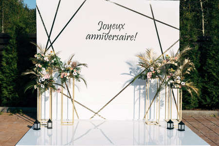 Floral photozone on party celebration, made of white plastic. Against the background of green foliage.の写真素材