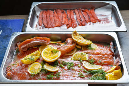 Salted and sliced pink fresh salmon, laid out on a baking sheet.の写真素材