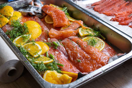 Salted and sliced pink fresh salmon, laid out on a baking sheet.