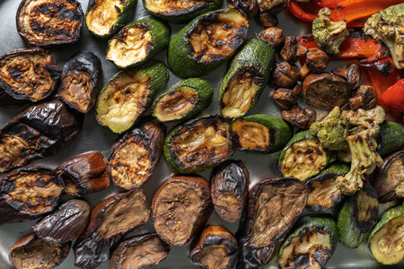 Grilled zucchini, mushrooms and Brussels sprouts. Laid out on a stainless steel baking sheet, top...