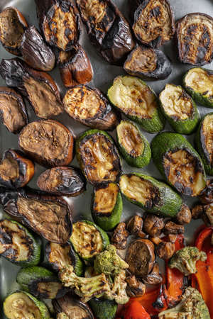 Grilled zucchini, mushrooms and Brussels sprouts. Laid out on a stainless steel baking sheet, top view.の写真素材