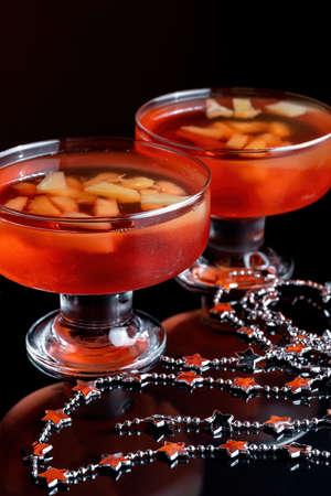 Orange jelly on a beautiful bowl with fruit pieces inside. Black background.の写真素材