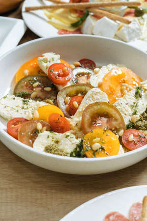 Salad with tomatoes, pine nuts and cheese. Vertical photographyの写真素材
