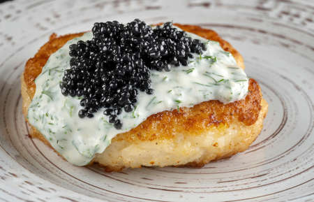 Draniki with black caviar and dill sauce on a beautiful plate.の写真素材