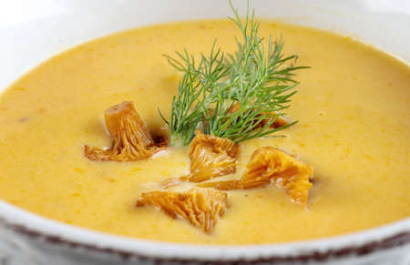 Cream soup with mushrooms chanterelles and herbs on black backgroundの写真素材