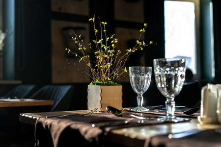 The interiors of the restaurant are in rustic style, a beautiful sunbeam shines on the glasses. Side viewの写真素材