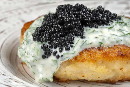 Draniki with black caviar and dill sauce on a beautiful plate.の写真素材