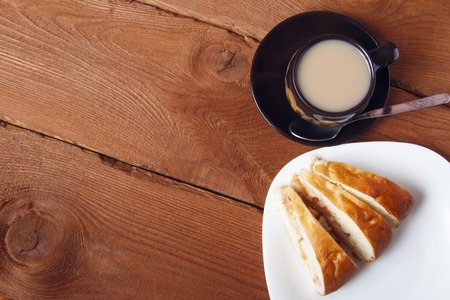 Fresh homemade apple pie and tea with milk on a wooden backgroundの写真素材