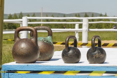 Iron weight on wooden platform. The background is blurred. Rustic backgroundの写真素材
