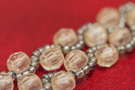Multicolored blanks for beads close-up. Macro photo on a red background.の写真素材
