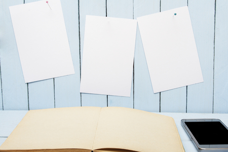 Blank page open book on wooden table. White paper for message on wooden wall.の写真素材