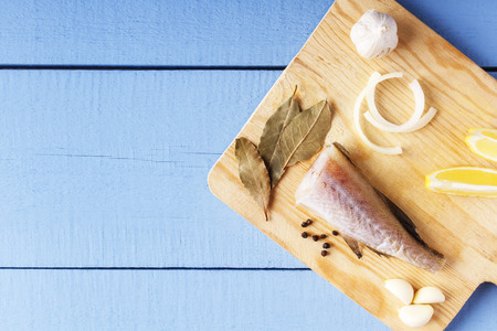 Top view on wooden table with ingredients for cooking. Fresh organic vegetables and sea fish on...