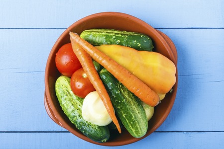 Organic cucumbers, tomatoes, carrots, bell pepper and onoin for vegetarian food. Healthy lifestyle concept. Top view from above. Copy space.の写真素材