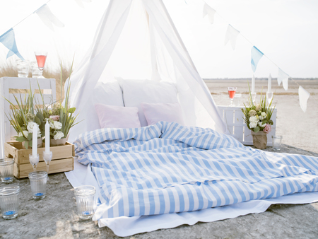 Bohemian style outdoor picnic. Bright scene of romantic beach dining.の写真素材