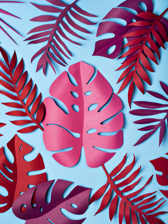 Bright tropical paper leaves on pastel blue background. Summer concept. Flat lay.の写真素材