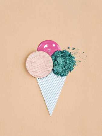 From above shot of arranged eyeshadow powder with gloss in shape of ice cream cone for summer concept.の写真素材