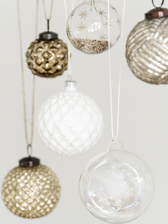 Close-up of hanging glass and crystal golden baubles in composition on white background.の写真素材
