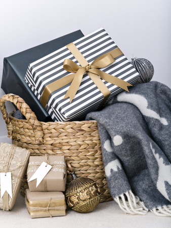 Composition with blanket and decorated Christmas presents in basket.の写真素材