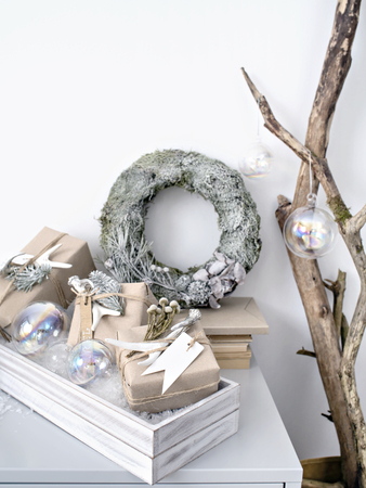 Beautiful New Year composition of silver wreath with glass shiny baubles and wrapped gift boxes.の写真素材