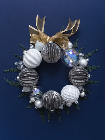 Gorgeous Christmas wreath made of vintage silver and white balls with golden ribbon bow on the top. Winter holidays decoration.の写真素材