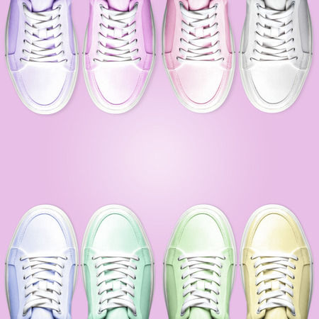 From above shot of collection of multicolored sneakers for sale standing in two rows on pink backgroundの写真素材