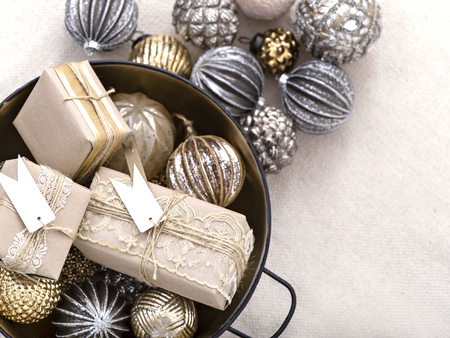 From above shot of arranged shiny balls in bowl with wrapped gift boxes for Christmas holiday.の写真素材