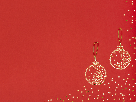 From above symbols of decorative baubles of little ornament stars with threads on red background.の写真素材