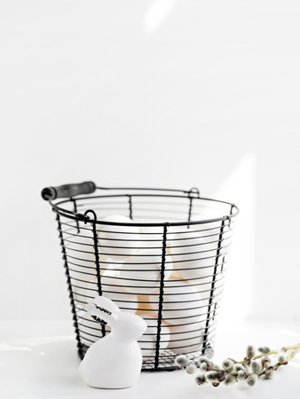 White bunny figurine and white eggs in basket as Easter concept composition.の写真素材
