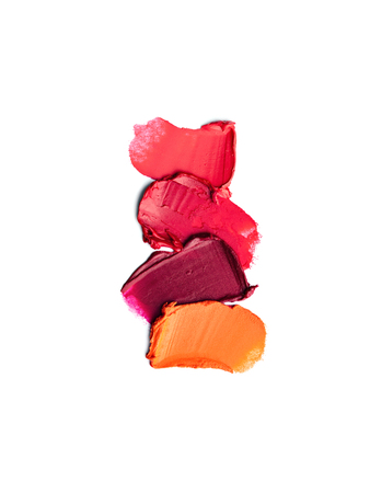 Colorful lipstick strokes isolated on white background. Makeup texture. Creative composition of cosmetic products.の写真素材