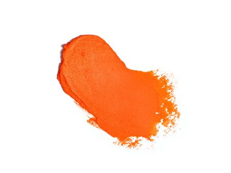 Orange color lipstick stroke isolated on white. Smudged cosmetics product. Makeup background.の写真素材