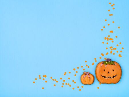 Halloween gingerbread on light blue background. Cute pumpkin shaped treats. Homemade ginger cookies. Minimalist Halloween background. Top view, copy space.の写真素材