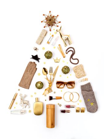 Golden toned feminine accessories and cosmetics laid out as a Christmas tree decorated with golden star sequins. Gifts guide for her. Flat lay, top view. Copy space for text.の写真素材
