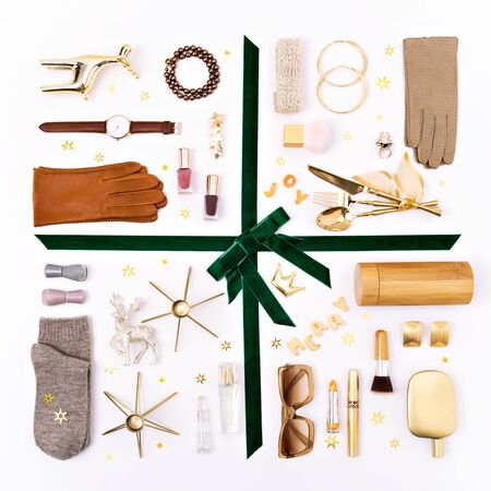 Christmas objects and gifts laid out in the shape of a gift box decorated with velvet ribbon and bow. Feminine accessories and cosmetics as a gifts guide for her. Overhead view, flat lay.の写真素材