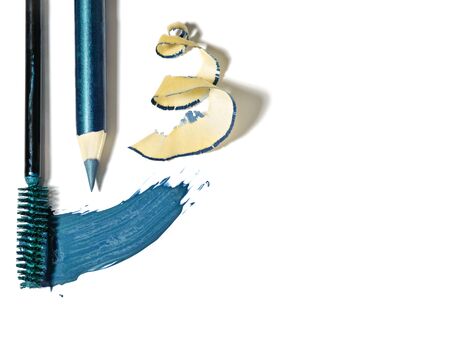 Top view of mascara brush stroke and eye pencil with shavings arranged as a border. Mosaic blue cosmetics isolated on white background.の写真素材