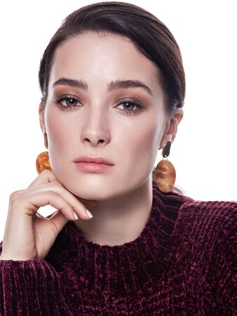Close up portrait of a confident pretty young woman with neutral brown smoky eyes makeup and glowing fresh skin on white background. Natural feminine beauty. Eye makeup and beauty concept.の写真素材