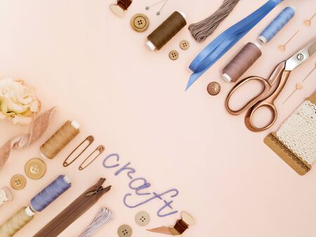 Elegant Composition of tailoring and sewing accessories in a beige tones. Pins, buttons, bobbins, lace, scissors, ribbons on pastel background. Concept of handmade, crafts, DIY.の写真素材