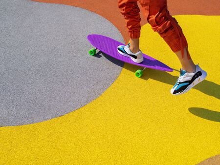 Portrait of a man riding a longboard on the cityscape background. Longboarding in the city. Extreme sport, leisure activity, hobby and motion concept.の写真素材